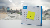 exclamation mark on a yellow post-it note, placed on a calendar