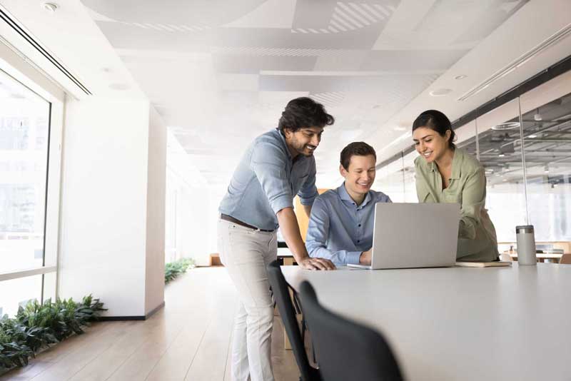 Three colleagues looking at a computer