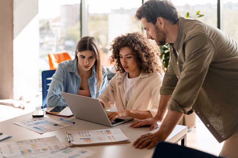 Three colleagues looking at a computer