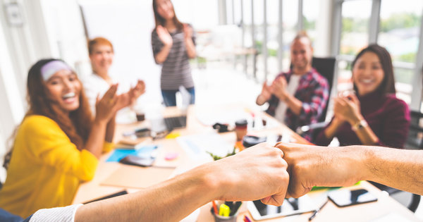 a group of enthusiastic young workers in a meeting