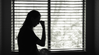 Silhouetted woman by a window 