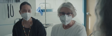 deux femmes assises ensemble. Ils portent des masques médicaux.